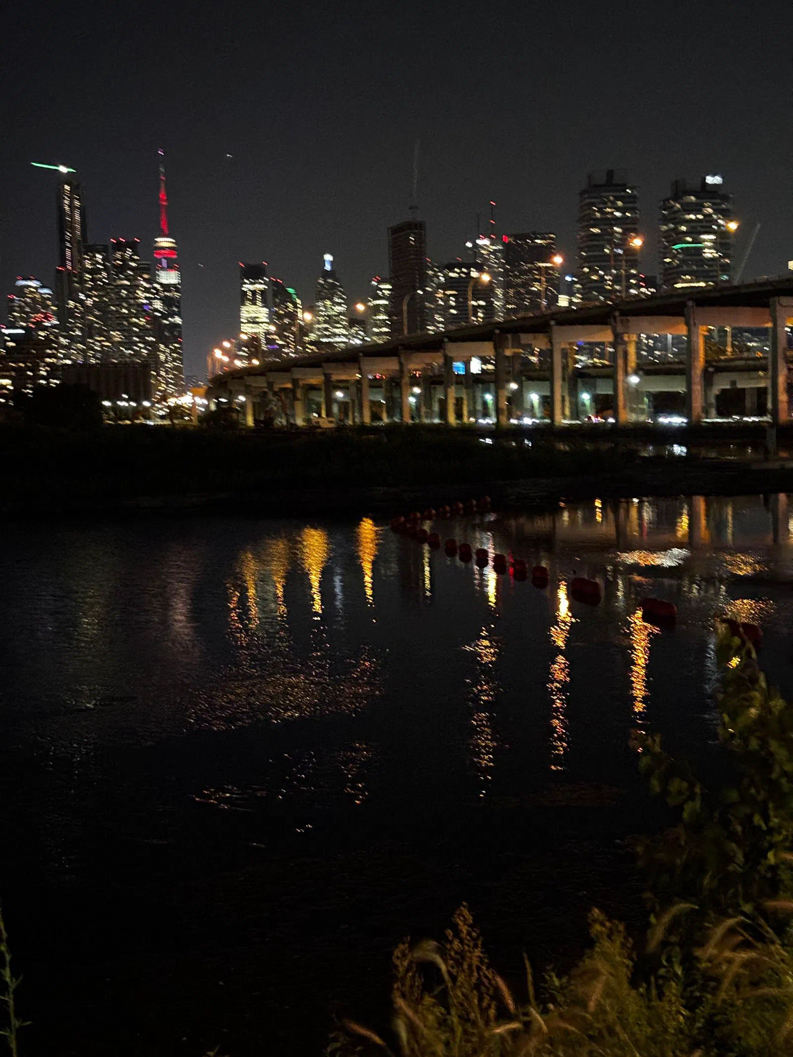 The Toronto skyline at night, reflected in the water, August 2026.