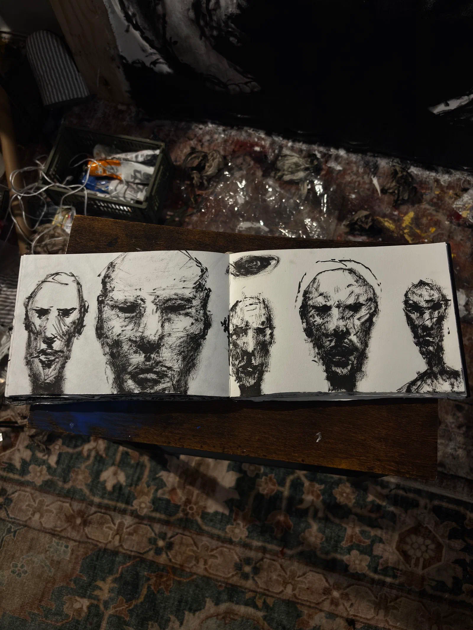 A sketchbook spread of five faces in ink, September 2026.